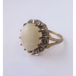 A 9-carat gold dress ring set with an opal surrounded by white gemstones (boxed)