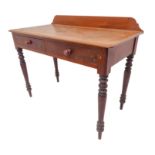 A mid-19th century mahogany writing table: galleried back; two half-width drawers; turned tapering