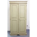 A shabby chic style painted wardrobe; outset cornice above two doors with fielded panels enclosing a