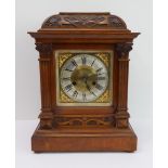 A late 19th century walnut-cased eight-day mantle clock: the domed top with Art Nouveau style