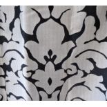 A pair of curtains in a metallic effect woven fabric with a striking black and silver design; triple