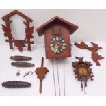 An unusual early 20th century miniature cuckoo-style clock complete with pendulum, weights and