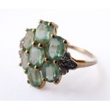 A lady's 9-carat gold dress ring (marked '375'): seven hand-cut light green stones in a flower-