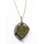 A striking silver-mounted labradorite heart-shaped pendant: the bale above a hand-cut square peridot