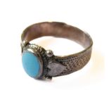 A silver textured ring: centrally mounted with a oval turquoise stone polished en cabochon (boxed)