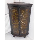 A late 18th century black lacquer and gilded bow-fronted corner cupboard on later short turned feet;