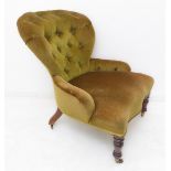 A 19th century green buttonback upholstered armchair having serpentine front and raised on turned