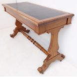 A 19th century walnut writing table; Rexine inset top above two ends united by a turned stretcher,
