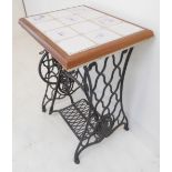 A tile-topped occasional table with a cast-iron treadle sewing machine base with decorative