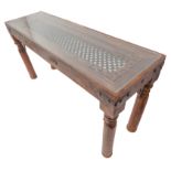 A carved Eastern-style hardwood, long side table with iron mesh centre raised on turned legs (