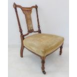 A late 19th century rosewood nursing chair of fine quality: boxwood-strung and marquetry decoration;