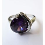 A lady's silver ring: centrally set with a faceted hand-cut amethyst and flanked by a pierced