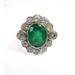An 18-carat gold ring set with a large emerald and diamond cluster, size O