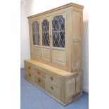 An early 20th century oak dresser of large proportions; outset cornice above three leaded-light
