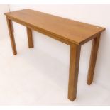 A modern light oak side table on square legs (147.5 x 46 x 76 cm high)