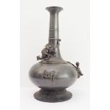 A late 19th century Japanese pewter or paktong vase of bottle form: the flaring lip above a slightly