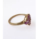 A lady's 9-carat yellow gold dress ring: set with four amethyst coloured high-cut stones, flanked by