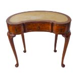A good early 20th century kidney-shaped walnut writing desk: the conforming leather-inset top