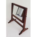 A small early 19th century mahogany-framed toilet mirror (27 cm wide x 26.5 cm high)