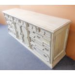 A long cream-painted shabby-chic-style sideboard: two central geometrically fronted cupboard doors