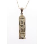 An Egyptian silver pendant engraved with hieroglyphs of vertical form, suspended from a silver chain