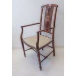 An Edwardian mahogany and boxwood-strung open armchair: arched concave top-rail above vertical