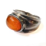 A silver ring set with a central horizontal oval amber, ring size L/M