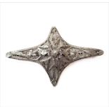 A silver filigreed brooch: central flowerhead in relief surrounded within a four-point elongated