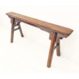 A small 19th century well-patinated bench: the rectangular (possibly fruitwood) top above a four-