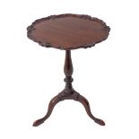 A mahogany wine table in 18th century style: carved pie-crust edged top above a turned stem and
