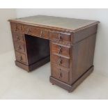 An early 20th century oak pedestal desk: the leather inset (tired) moulded top above an