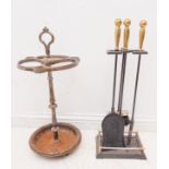A four-piece iron and brass-handled fire-iron set, together with a sectional iron umbrella and stick