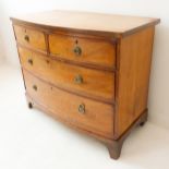 An early 19th century bow-fronted figured mahogany chest of small proportions: the slightly