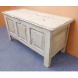 An antique panelled oak chest, later painted in shabby-chic style: the overhanging top opening to