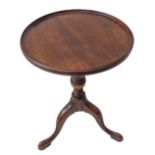 A circular topped mahogany wine table in George III style: turned stem and three downswept legs