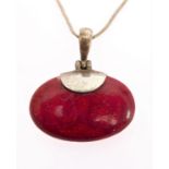 A silver mounted red hardstone pendant of oval form polished en cabochon suspended from a silver