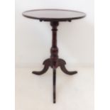 An early 19th century circular tilt-top oak occasional table; dished top above turned stem and three