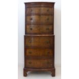 A mid-20th century bow-fronted walnut chest-on-chest (one piece): six full-width graduated drawers