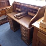 A 1920s/30s roll-top desk: the tambour top opening to reveal an interior with varying sized