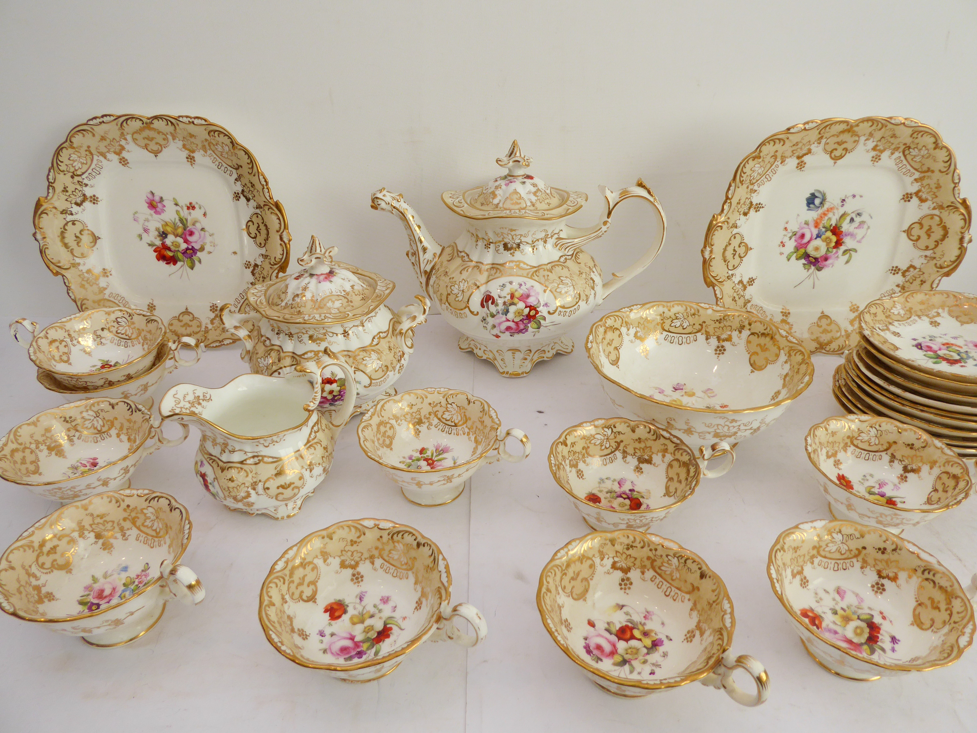 A 19th century ceramic tea service hand-gilded and decorated in enamels with various floral sprays