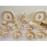 A 19th century ceramic tea service hand-gilded and decorated in enamels with various floral sprays
