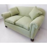 A two-seater green and polka dot upholstered sofa with drop-arm mechanism (148cm wide x 80cm deep