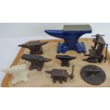 Six miniature anvils (five cast-iron and one stoneware example) and two miniature vices. The largest