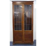 An early 20th century oak display cabinet: two leaded-light doors enclosing shelves and above