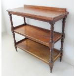 A late 19th/early 20th century three-tier oak buffet: galleried top above turned annulated