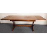 An early/mid 20th century oak draw leaf dining table on shaped ends united by a stretcher (220cm