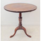 A George III period circular tilt-top mahogany occasional table; turned stem and on three