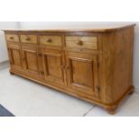 A large pine sideboard in 19th century style: the overhanging top above four frieze drawers and four