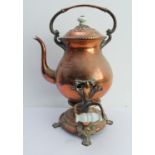 A heavy copper kettle on two-handled stand