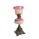 A 19th century brass opaline glass and cast-iron oil lamp: the crimped-edge cranberry and opaline-